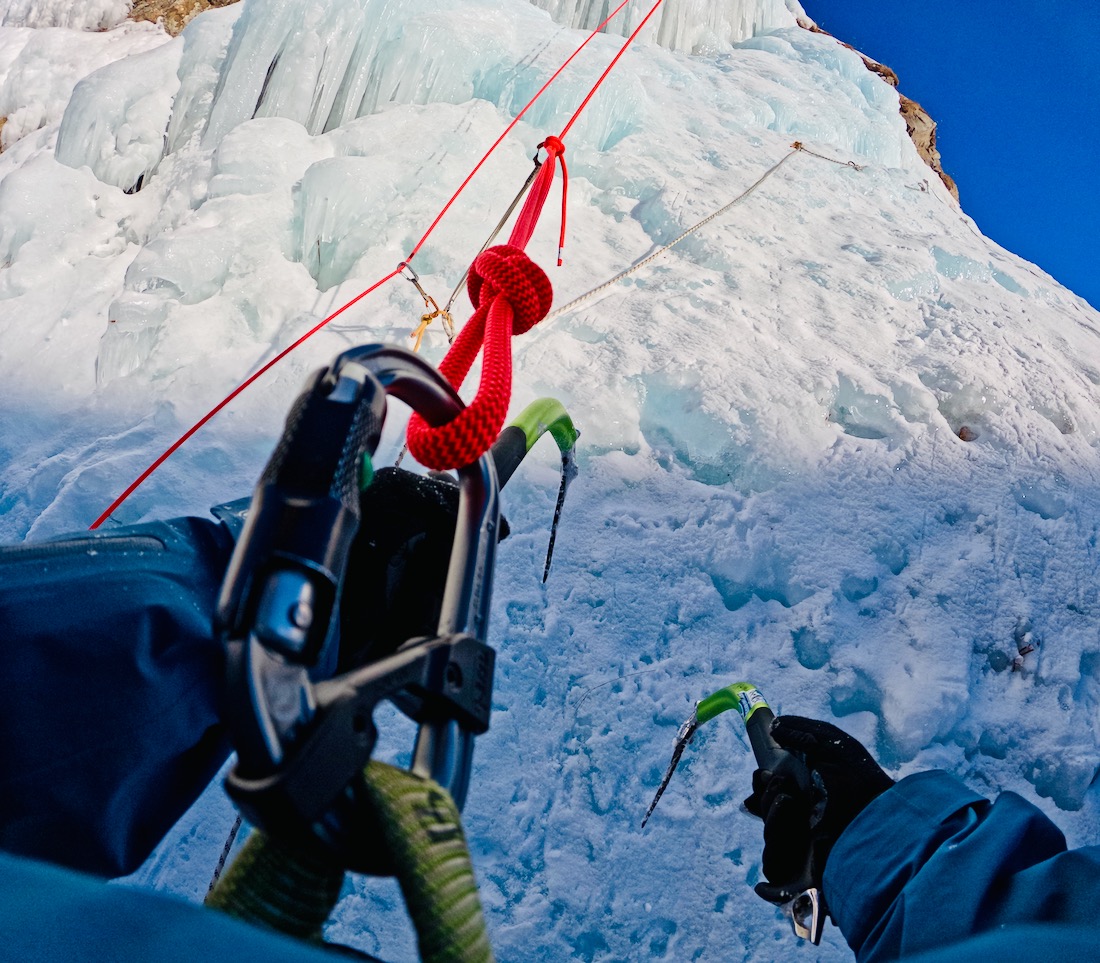 Flo klettert mit Eisgeräten die Eiswand hoch