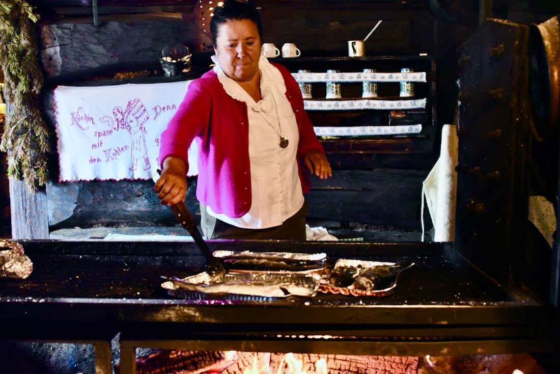 Gerli bereitet die Forellen auf dem offenen Grill in der Tauernkaralm zu