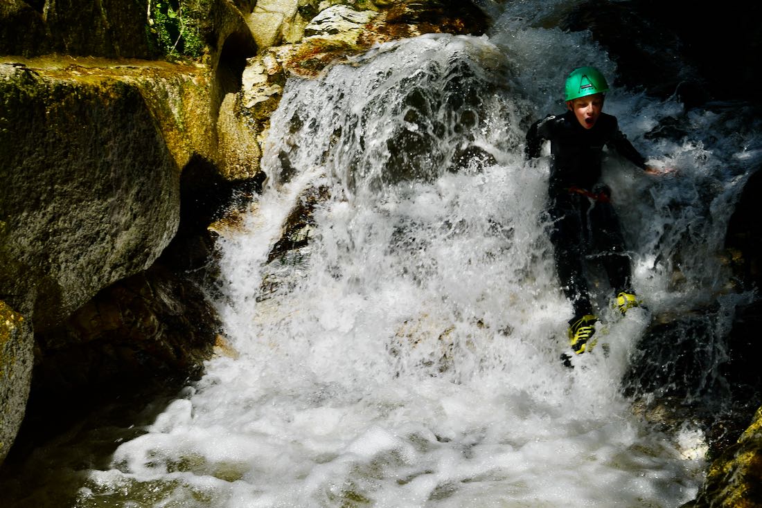 Ben rutscht die Steine im Bach hinunter