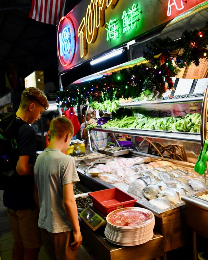 Flo und Ben suchen sich etwas zu Essen auf dem Food Court
