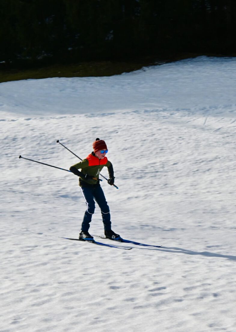 Ben fährt mit Langlaufski den Berg hinab