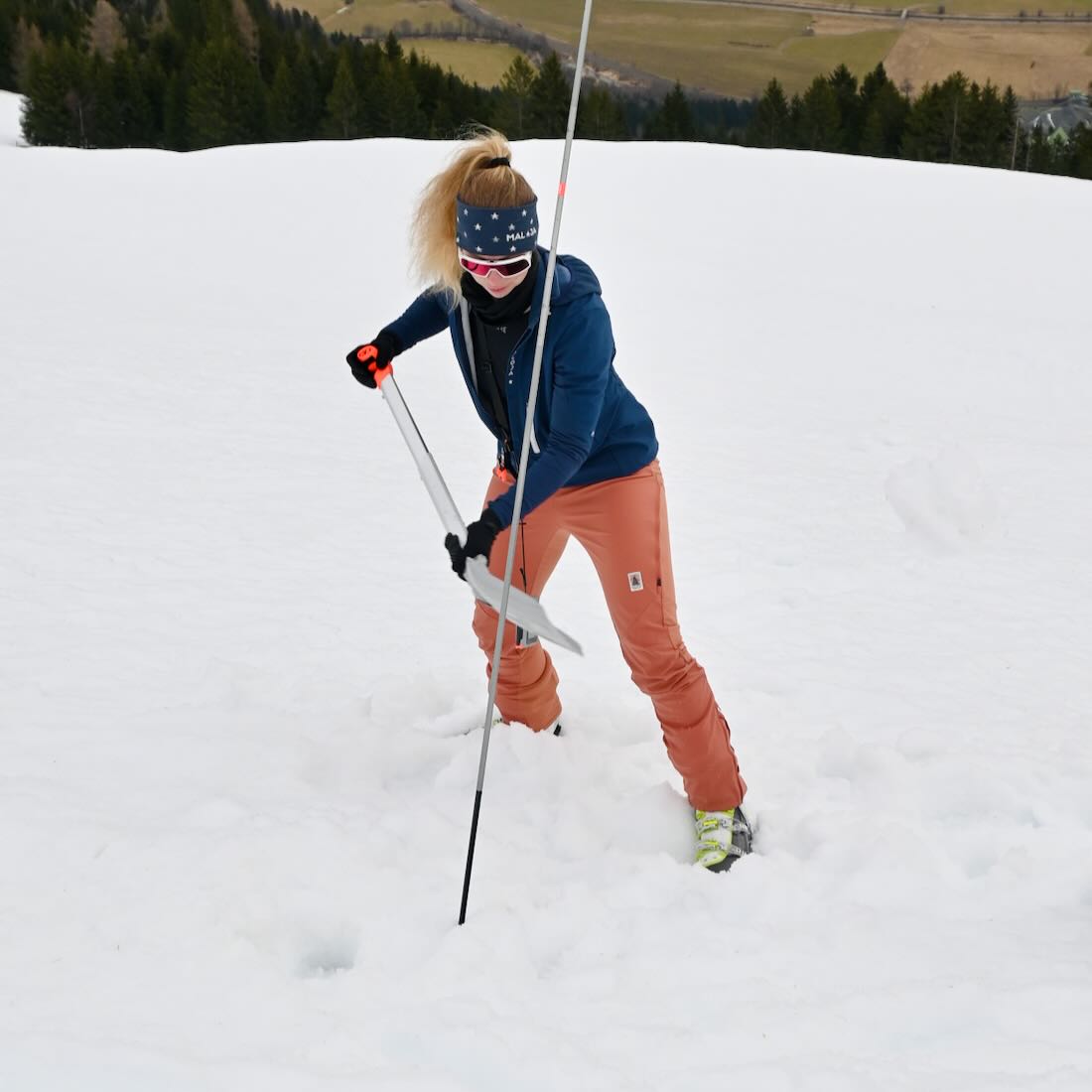 Melanie sucht mit der Schaufel nach dem verschütteten Rucksack