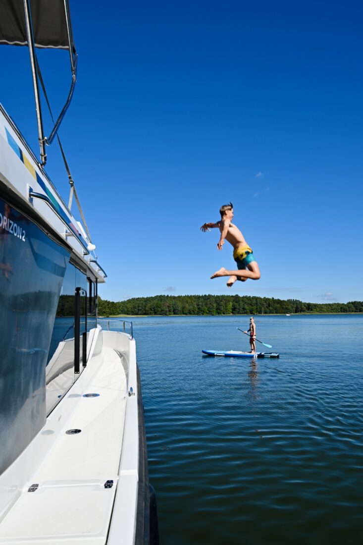 Flo springt ins Wasser - Benni dahinter mit SUP