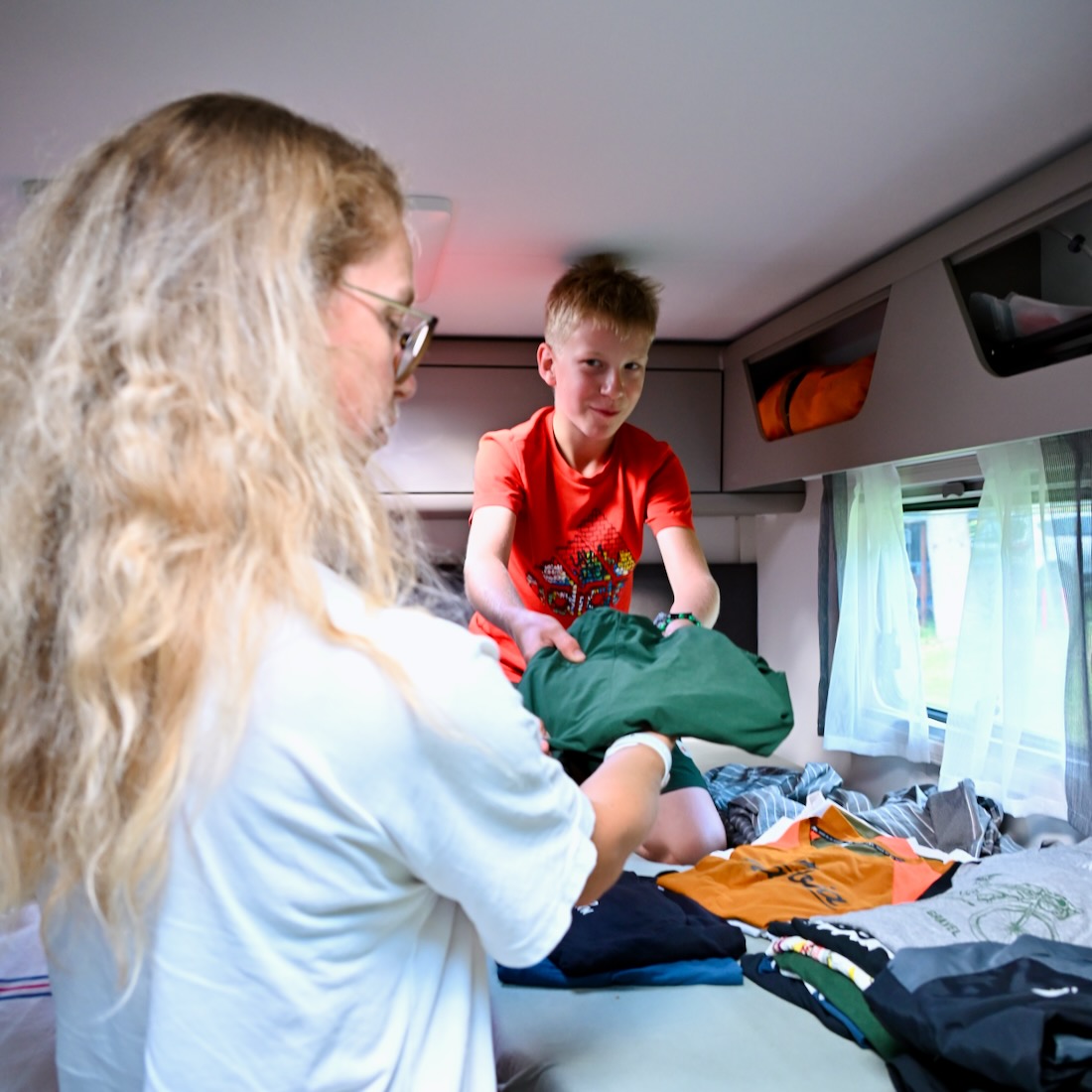 Melanie und Ben räumen Sachen in den Carado Camper