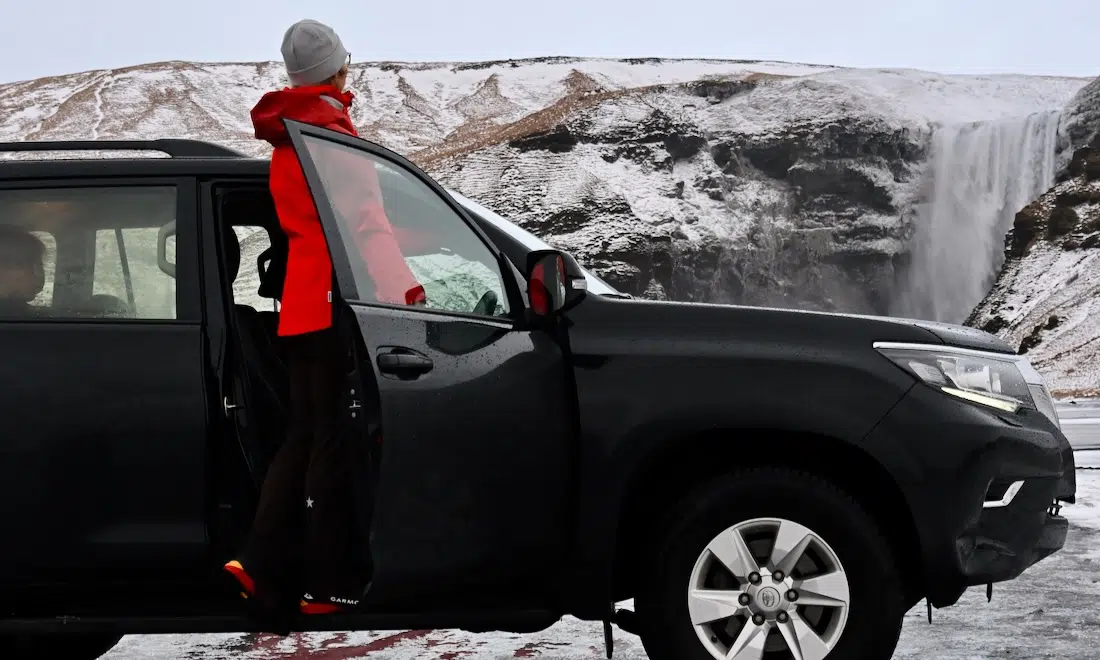Mit dem Mietwagen vor dem Skogafoss in Island