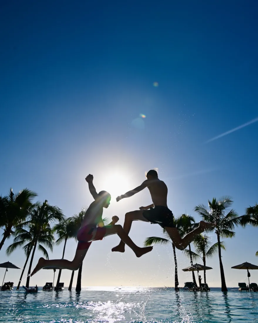 Flo und Ben springen ind en Pool des Paradis Beach Comber