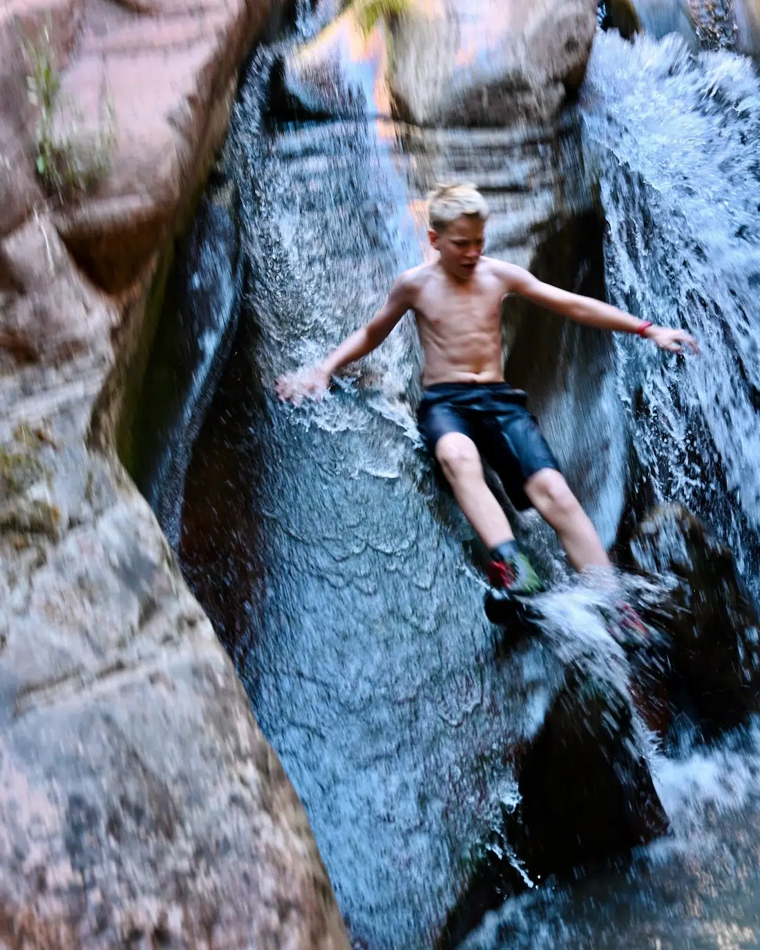 Ben rutscht den Wasserfall der Kanarra Falls hinunter
