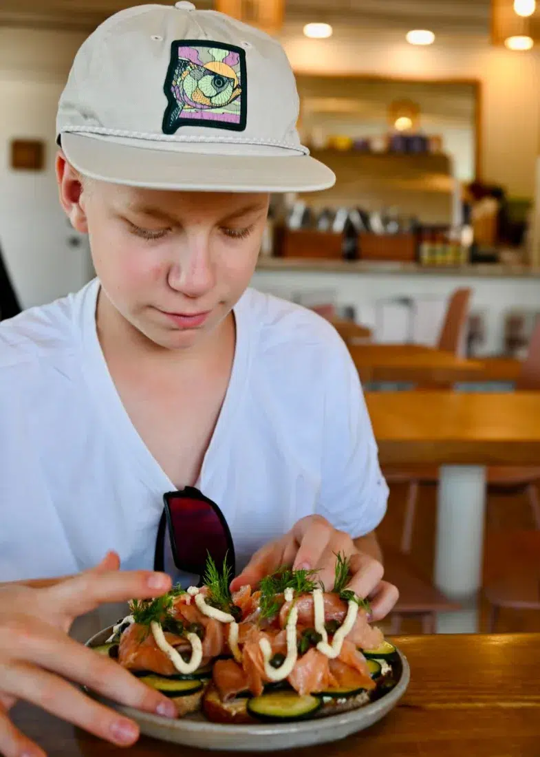 Ben isst Lachsbrot im Café Wildcraft Kitchen