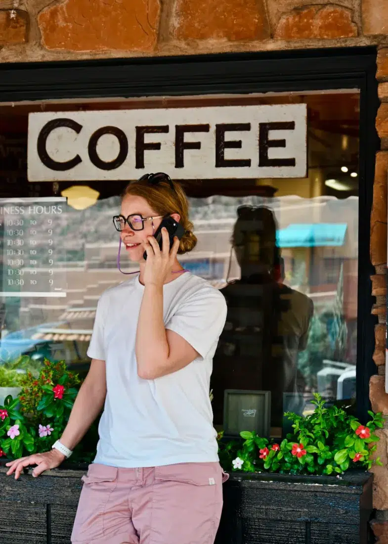 Melanie telefoniert vor einem Coffee Shop