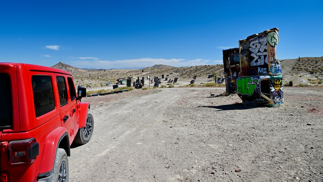 fravely mit rotem Jeep beim International Car Forest of The Last Church