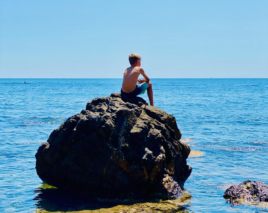 Flo genießt das Meer auf einem Felsen